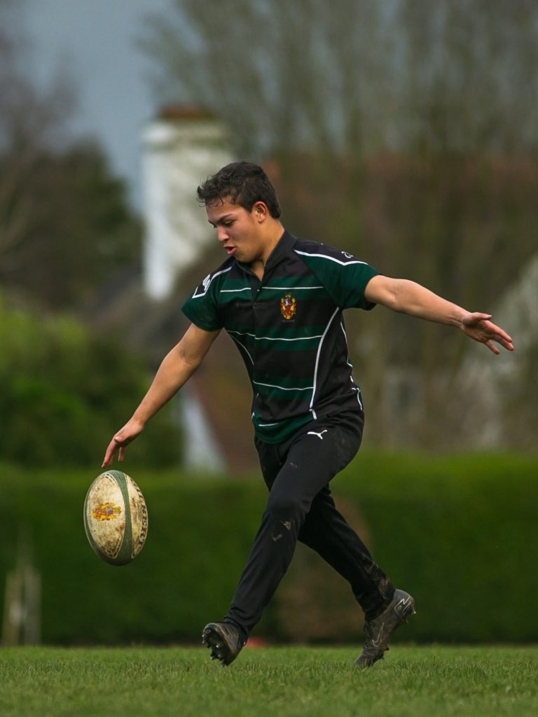 Young man about to kick a rugby ball